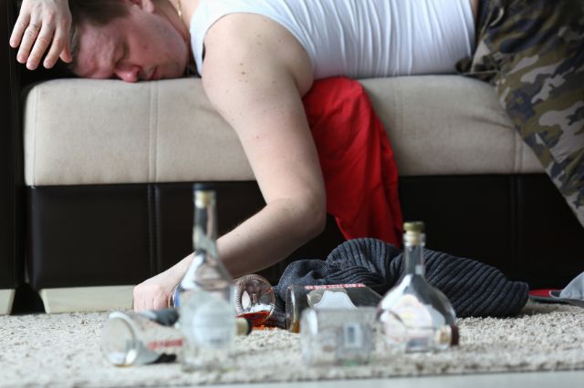 hombre sofá alcohol resaca atracón binge-drinking botellas vasos bebidas