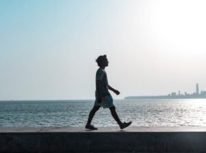 Persona caminando por la playa en verano reflexionando, representando la prevención de recaídas en adicciones durante las vacaciones